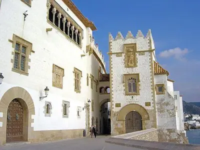 a large white building with a tower in front of it at Capricho Apartamento Sitges in Sitges