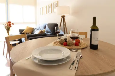 a table with a plate and a bottle of wine at Capricho Apartamento Sitges in Sitges