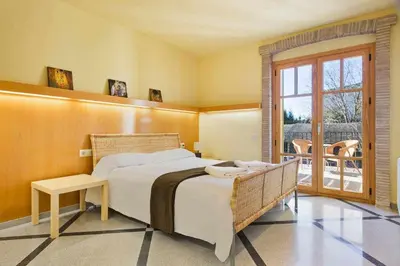 a bedroom with a large bed and a balcony at Xalet de la Muntanya, El Bruc-Montserrat in El Bruc