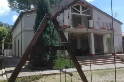 a swing set in front of a house at Xalet de la Muntanya, El Bruc-Montserrat in El Bruc