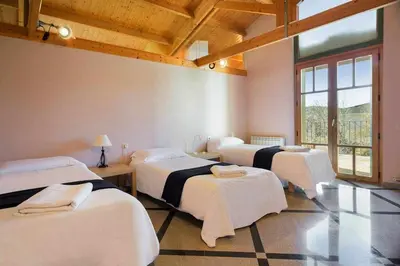 a room with four beds in a room at Xalet de la Muntanya, El Bruc-Montserrat in El Bruc