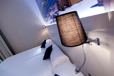 a bedroom with a bed with a lamp on it at Hostal BCN Ramblas in Barcelona
