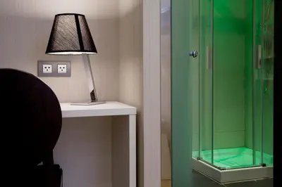 a bathroom with a glass shower and a lamp at Hostal BCN Ramblas in Barcelona