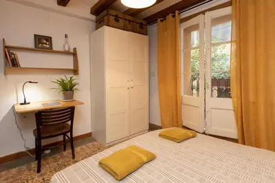 a bedroom with a bed and a desk and a window at ApartEasy - Central Gracia Apartments in Barcelona