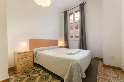 a small bedroom with a bed and a window at ApartEasy - Central Gracia Apartments in Barcelona