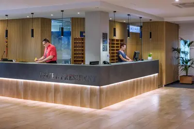 two people standing at the reception desk of a hotel depositasy at Hotel President in Calella
