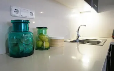 two glass jars sitting on a kitchen counter next to a sink at Love Sitges & Beach in Sitges