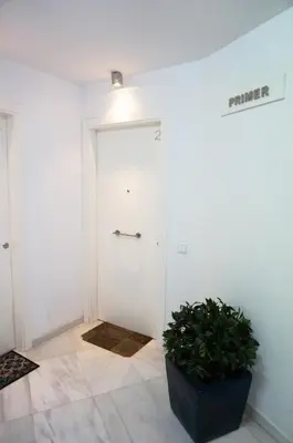 a hallway with a white door and a potted plant at Love Sitges & Beach in Sitges