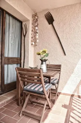 a wooden table and chair with a vase of flowers at Cova Safaja in San Quírico Safaja