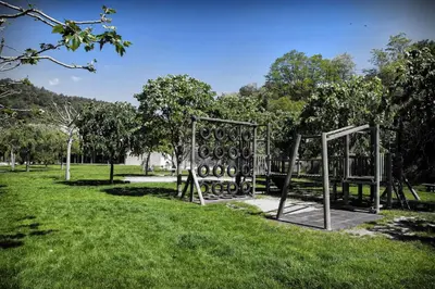 a park with an empty swing set in the grass at Cova Safaja in San Quírico Safaja