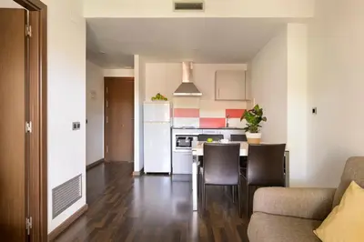 a kitchen and living room with a table and chairs at SG Marina 54 Apartments in Castelldefels