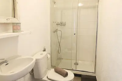 a white room with a door and a table and a mirror at Fridays Flats Villa Alba in Barcelona