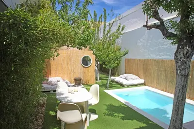 a small backyard with a pool and a table and chairs at Fridays Flats Villa Alba in Barcelona
