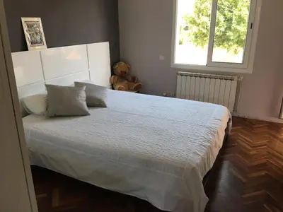 a bedroom with a white bed with a teddy bear at Villa Masnou Homelydays in El Carrer del Canonge