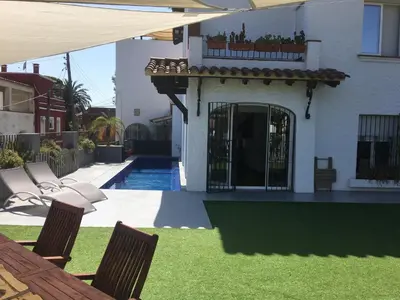a house with a yard with two chairs and a pool at Villa Masnou Homelydays in El Carrer del Canonge