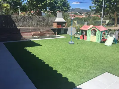 a playground with a toy house and a slide at Villa Masnou Homelydays in El Carrer del Canonge