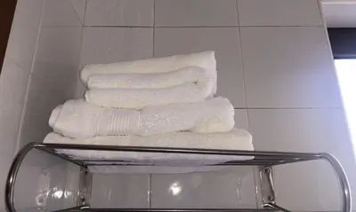 three towels stacked on a shelf in a bathroom at Hostal Sant Pau in Barcelona