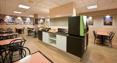 a restaurant with tables and chairs and a tv on a counter at Hostal Barcelona in Barcelona