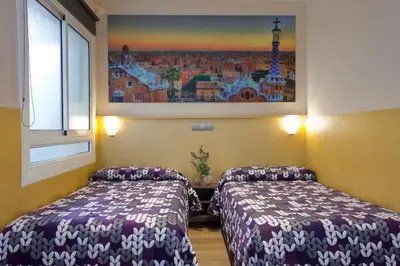 two beds in a room with a picture on the wall at Hostal Barcelona in Barcelona
