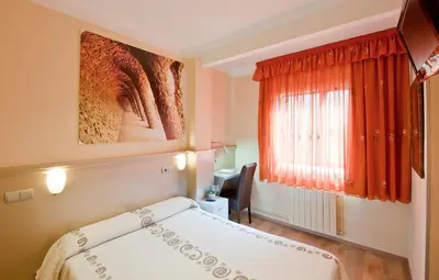 a bedroom with a bed and a red window at Hostal Barcelona in Barcelona