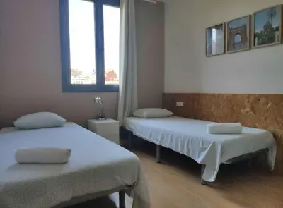 a room with two beds and a window at Diagonal Apartments in Barcelona