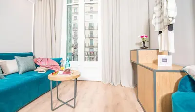 a living room with a blue couch and a table at Mosaic by Ona in Barcelona