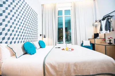 a bedroom with a large white bed with blue pillows at Mosaic by Ona in Barcelona