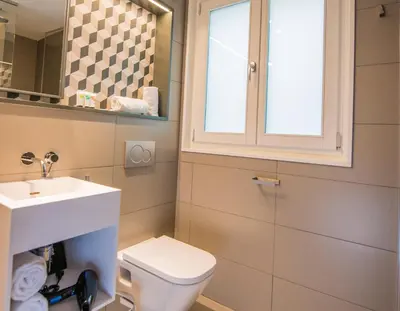 a bathroom with a toilet and a sink and a window at Mosaic by Ona in Barcelona