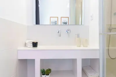 a white bathroom with a sink and a mirror at Casa Premia in Premiá de Mar
