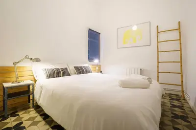 a bedroom with a large white bed and a lamp at Casa Premia in Premiá de Mar