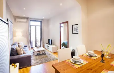a living room with a table and a dining room at Apartments Barcelona & Home Deco Viladomat in Barcelona