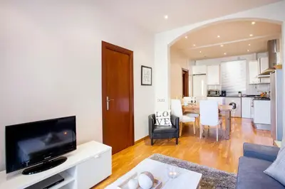 a living room with a tv and a kitchen at Apartments Barcelona & Home Deco Viladomat in Barcelona