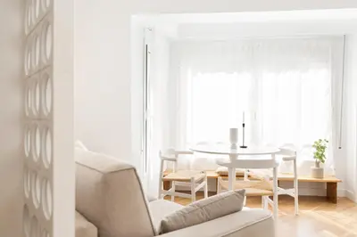 a white living room with a table and chairs at WOW Apartments by Olala Homes in Hospitalet de Llobregat