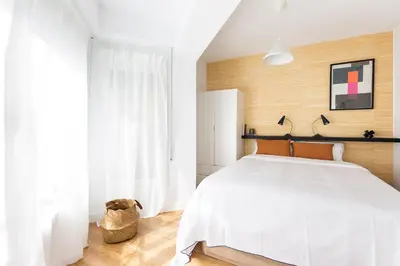 a bedroom with a white bed and a large window at WOW Apartments by Olala Homes in Hospitalet de Llobregat