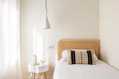 a bedroom with a white bed with a black and white pillow at WOW Apartments by Olala Homes in Hospitalet de Llobregat