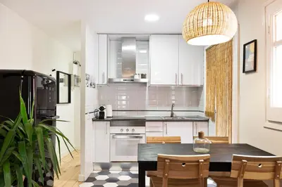 a kitchen with a table and chairs and a kitchen with white cabinets at WOW Apartments by Olala Homes in Hospitalet de Llobregat