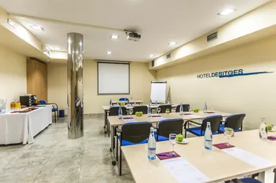 a conference room with tables and chairs and a projection screen at Hotel Desitges in Sant Pere de Ribes