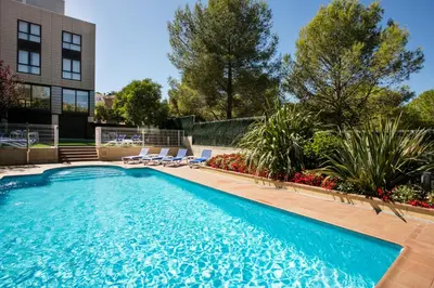 a swimming pool with lounge chairs next to a building at Hotel Desitges in Sant Pere de Ribes