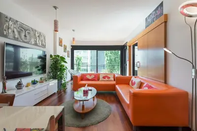 a living room with an orange couch and a table at Jie Apartment in Sant Adria de Besos