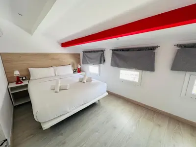 a bedroom with a white bed and a red ceiling at Rainbow Apartments BY BLAUSITGES in Sitges