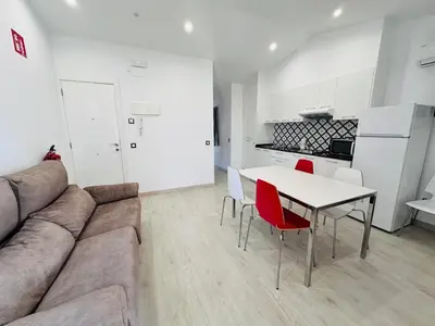 a living room with a couch and a table and chairs at Rainbow Apartments BY BLAUSITGES in Sitges