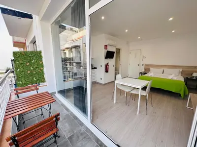 a room with a bed and a table and chairs at Rainbow Apartments BY BLAUSITGES in Sitges