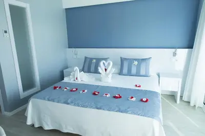 a blue bedroom with a bed with red roses on it at Masd Mediterraneo Hotel Apartamentos Spa in Castelldefels