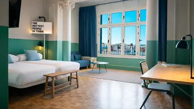 a hotel room with a bed and a desk and window at Casa Gracia in Barcelona