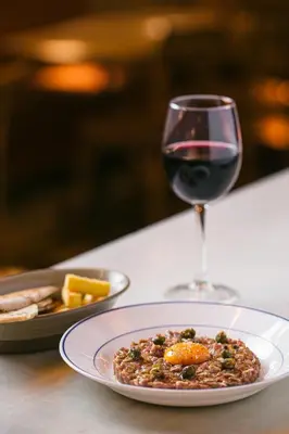 a plate of food and a glass of wine on a table at Casa Gracia in Barcelona