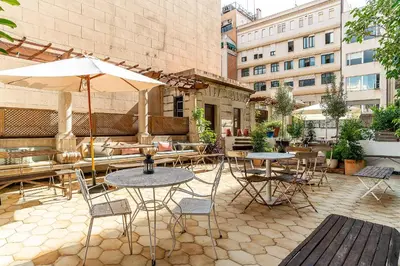 a patio with tables and chairs and an umbrella at Casa Gracia in Barcelona
