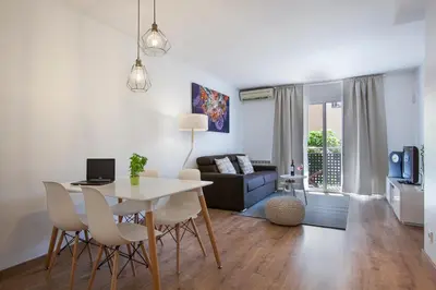 a living room with a table and chairs and a couch at Tendency Apartments Fira in Hospitalet de Llobregat