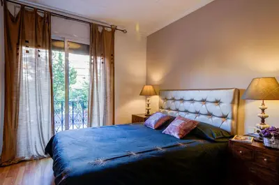 a bedroom with a blue bed with a window at Valencia Suite ArchsenseApartments in Barcelona