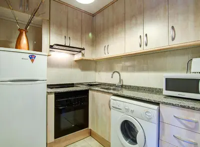 a kitchen with a white refrigerator and a dishwasher at Valencia Suite ArchsenseApartments in Barcelona