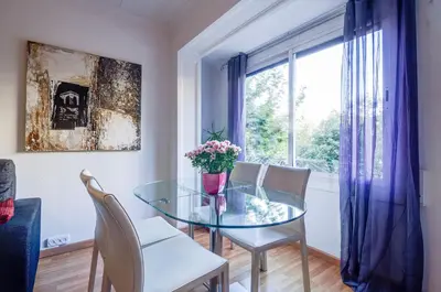 a dining room with a glass table and chairs and a window at Valencia Suite ArchsenseApartments in Barcelona